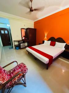 a bedroom with a large bed and a chair at Moon Valley Cottage in Kovalam +28 photos