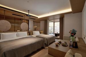 een hotelkamer met twee bedden en een raam bij Huazhu Luxurious Mountain Courtyard Private Hot Spring Resort in Longmen