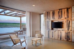 a living room with a large entertainment center with a tv at Rosell Boher Winery Lodge & Spa in Agrelo