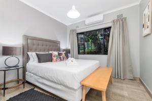 ein Schlafzimmer mit einem weißen Bett und einem Fenster in der Unterkunft Bird of Paradise in Tzaneen