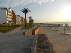 una acera junto a una playa con árboles y edificios en Departamento con Vista al Mar- Condominio Nautico Las Velas, en Paracas