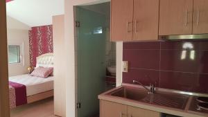 a kitchen with a sink and a bed in a room at Studios Rania in Skala Potamias +63 photos
