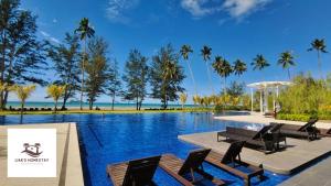 a swimming pool with chairs and the beach at Sematan SeaView Apartment,Highest Floor in Sematan