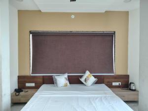 a large window above a bed in a room at Hotel O Eternity Stays in Rao