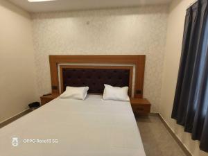 a bedroom with a large bed with two white pillows at Hotel O AVR STAY INN in Bhauli +9 photos