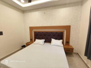 a bedroom with a large bed with a wooden headboard at Hotel O AVR STAY INN in Bhauli
