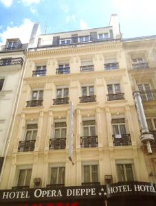 un grande edificio con un cartello di fronte di Hôtel Opéra Dieppe a Parigi