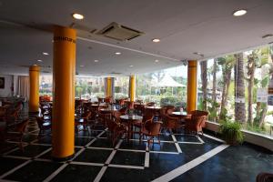 a restaurant with yellow columns and tables and chairs at Hotel Mexico in Vera