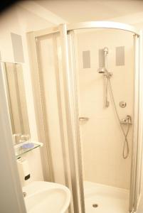 a white bathroom with a shower and a toilet at Hotel Herian in Parsdorf