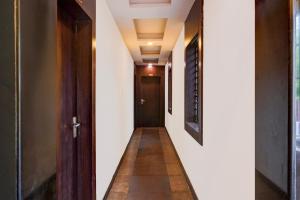 un pasillo con paredes blancas y una puerta negra en Townhouse Madan Mahal Railway Junction Formerly Annpurna Inn, en Jabalpur