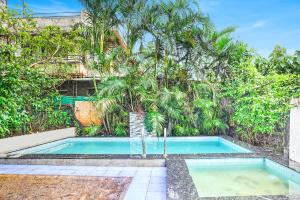 a swimming pool in front of a building with trees at Villa Bliss by Palette Homes Lonavala in Lonavala