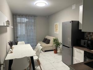 cocina y sala de estar con mesa y nevera en ПОМЕШКАННЯ на площі Польський ринок, en Kamianets-Podilskyi