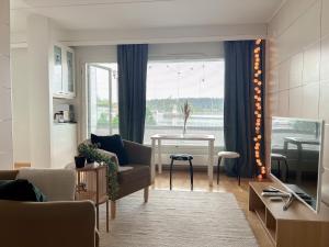ein Wohnzimmer mit Sofa und Tisch in der Unterkunft Kaksio järvinäkymällä ja saunalla Lahden Satamasta in Lahti