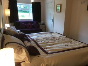 a bedroom with a bed with a blanket on it at Pen-y-Bont Guest House in Amroth