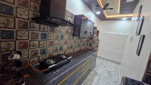 a kitchen with a stove and a wall with tiles at 2BHK Home fully furnished at Sahid Nagar near INOX in Bhubaneshwar +5 photos