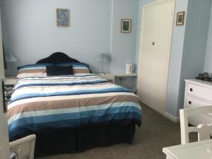 a bedroom with a bed and a white dresser and a bed sidx sidx sidx at Pen-y-Bont Guest House in Amroth