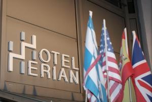 tres banderas delante de un cartel de hotel ireland en Hotel Herian, en Parsdorf