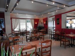 a restaurant with wooden tables and chairs and red walls at Le Lion d'Or in La Chaise-Dieu