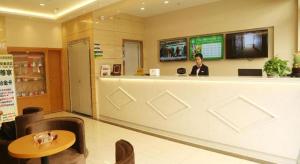 a man sitting at a bar in a restaurant at GreenTree Inn Huaian Gaogou Town First Street Shell Hotel in Zhangtangzhuang