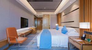 a hotel room with a large bed and a desk at Excemon Yuyao Hemudu Hotel in Ningbo +230 photos