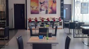a dining room with tables and chairs with flowers on them at Jinjiang Inn Pingliang West Railway Station Xuanhe New City in Pingliang
