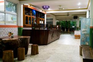 un restaurante con bar con taburetes de madera en Hotel Puntarenas Beach, en Puntarenas