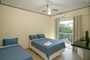 a bedroom with two beds and a ceiling fan at Pousada Colibri in Trindade