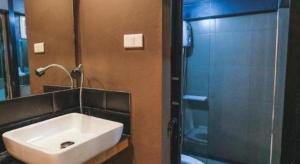 a bathroom with a sink and a glass shower at The Smart Hostel in Nakhon Ratchasima +38 photos