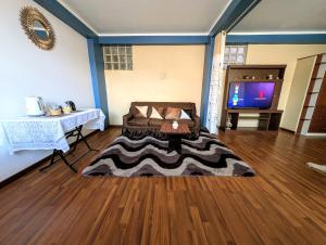 a room with a bed and a table and a television at MONOAMBIENTE Sicuani in Sicuani