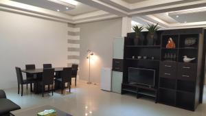ein Esszimmer mit Tisch und Fernseher in der Unterkunft Riviera Taouyah Hotel in Conakry