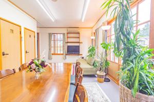 a dining room with a table and some plants at The Snowfront Apartment Nabe Sun -HAKUBA GORYU- in Hakuba