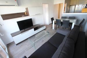 een woonkamer met een bank en een flatscreen-tv bij For a Stay Pineda Mar in La Pineda