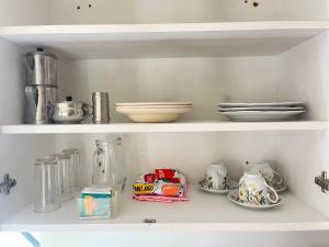 a shelf with dishes and other kitchen items on it at Hospedaje el Trujillanito in Víctor Larco Herrera +11 photos
