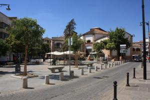 a street with benches and trees in a city at Arte de Cozina in Antequera