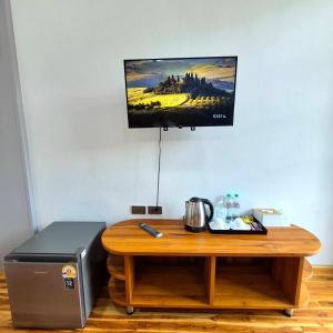 a table with a microwave and a television on a wall at One Sa-Kaeo Homestay in Ban Non Chan +47 photos