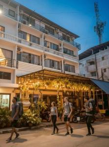 a group of people walking in front of a building at Youyen ll Hostel in Don Muang Airport
