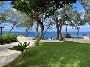 a park with trees and the ocean in the background at Rockpools - 5 Bedroom Oceanfront Villa in Hideaway Island