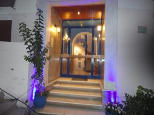 una puerta delantera de un edificio con luces púrpuras en Apergis Rooms, en Ermoupoli