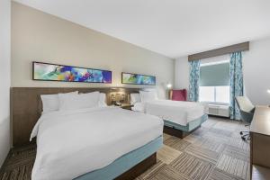 a hotel room with two beds and a desk at Hilton Garden Inn Gallatin in Gallatin +21 photos