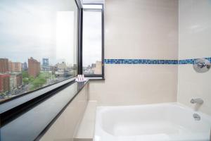 a bathroom with a bath tub and a window at Hotel Richland LES in New York