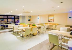 a dining room with tables and chairs at City Comfort Inn Nanning Normal University Mingxiu Metro Station in Nanning