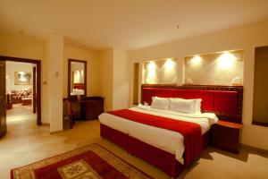 Un dormitorio con una cama grande con cabecero rojo. en Al Liwan Suites, en Doha
