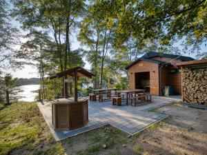 a wooden cabin with a picnic table and a grill at Biwak Na Skarpie in Wola