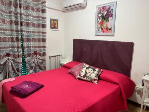 a bedroom with a red bed with a pillow on it at Etna View Affittacamere in Giardini Naxos