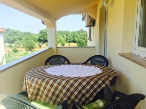 a balcony with a table and chairs and a window at Apartment Fuma in Marčana