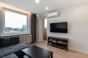 a living room with a couch and a flat screen tv at Panorama City View Apartment in Vilnius
