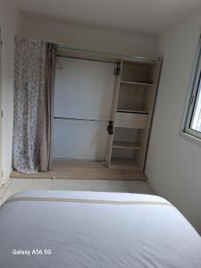 a bedroom with a white bed and a closet at Ti kaz Orion in Les Avirons +9 photos