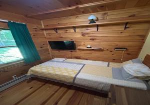 een slaapkamer met een bed in een blokhut bij Delaware River Poconos Riverfront Masthope in Masthope