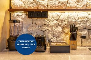 a counter with a blender and a stone wall at 2BDR Canggu Center -Rooftop & BBQ - Private Cook - Walk to Beach - Modern & Luxury in Canggu