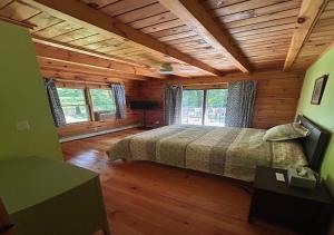 een slaapkamer met een bed in een blokhut bij Delaware River Poconos Riverfront Masthope in Masthope